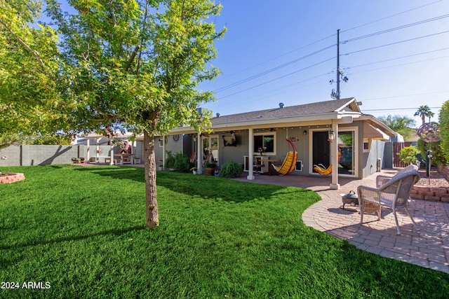 back of property featuring a yard and a patio