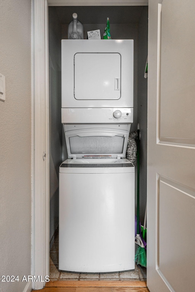 clothes washing area with stacked washer / dryer and light hardwood / wood-style floors