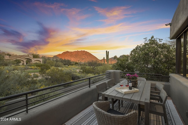 balcony at dusk featuring a mountain view