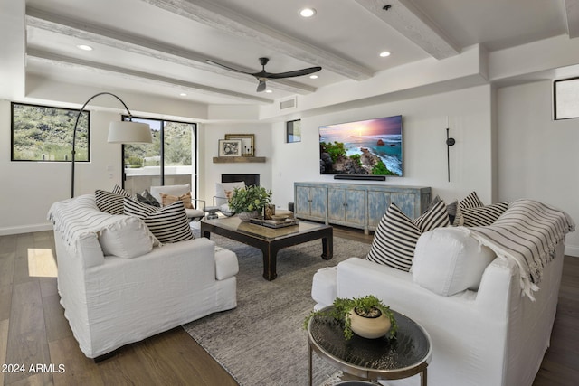 living room featuring ceiling fan, beamed ceiling, and dark wood-type flooring