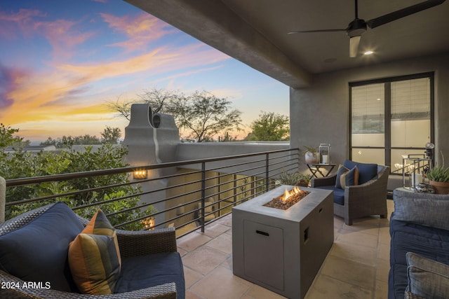 balcony at dusk with ceiling fan, an outdoor living space with a fire pit, and a patio