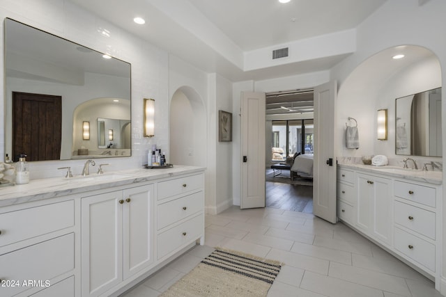 bathroom featuring tile patterned flooring, vanity, and backsplash