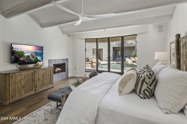 bedroom with dark wood-type flooring, a tile fireplace, beamed ceiling, access to exterior, and ceiling fan