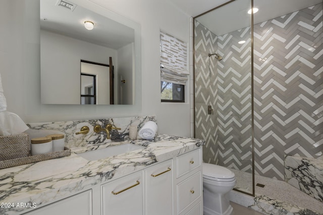 bathroom with vanity, toilet, and a shower with door