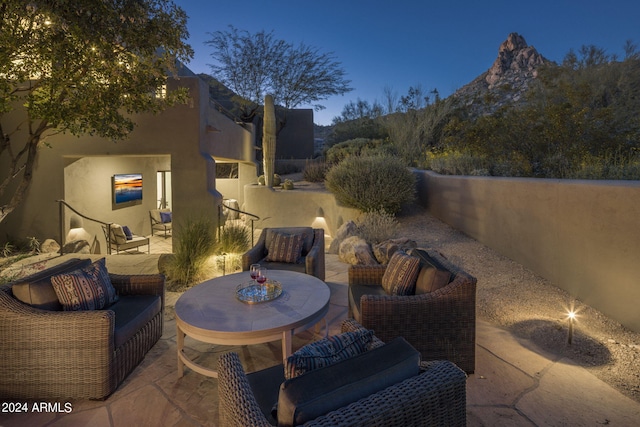 patio terrace at dusk featuring a mountain view and outdoor lounge area