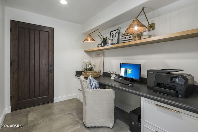 office with built in desk and concrete flooring