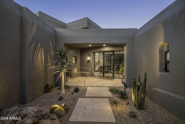 exterior entry at dusk with a patio