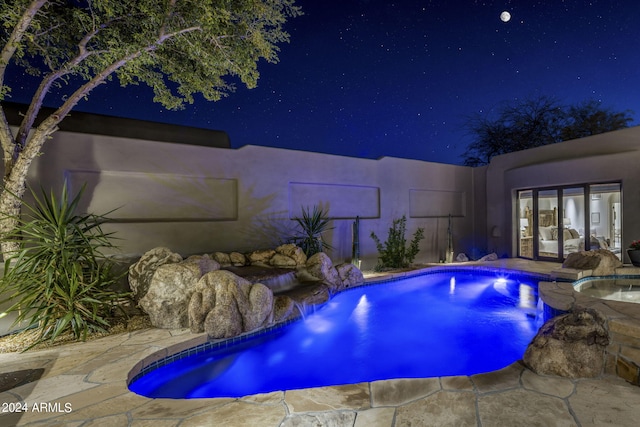 pool at night with french doors