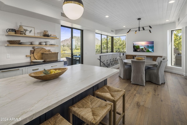 dining room with light hardwood / wood-style flooring and wooden ceiling