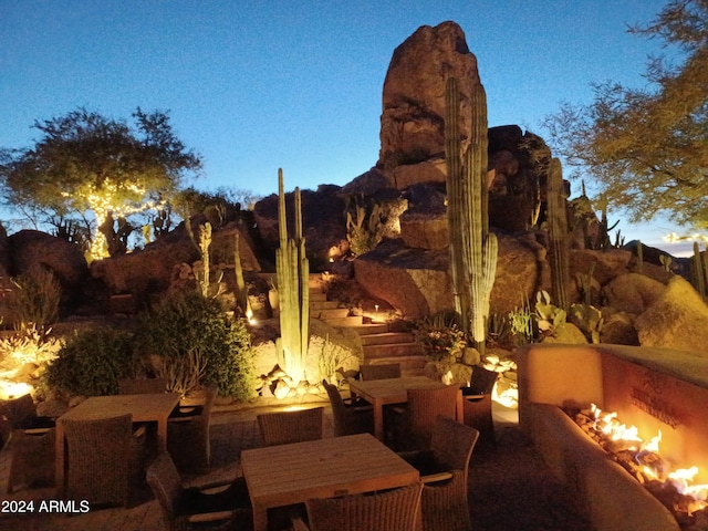 patio terrace at dusk featuring a fire pit