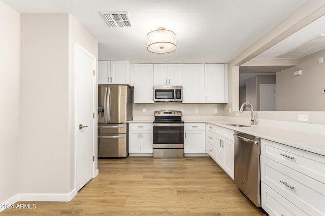 kitchen featuring sink, light hardwood / wood-style flooring, stainless steel appliances, and white cabinets