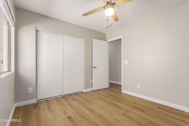 unfurnished bedroom with ceiling fan, a closet, and light hardwood / wood-style flooring