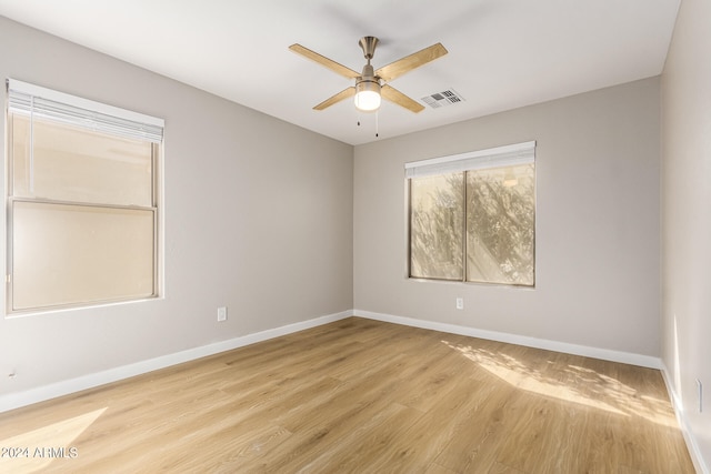 empty room with ceiling fan and light hardwood / wood-style flooring