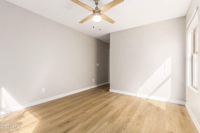 empty room featuring ceiling fan, light hardwood / wood-style floors, and a healthy amount of sunlight