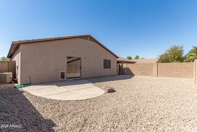 rear view of house with central air condition unit and a patio area