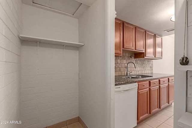 kitchen featuring dishwasher, light tile patterned flooring, decorative backsplash, and sink