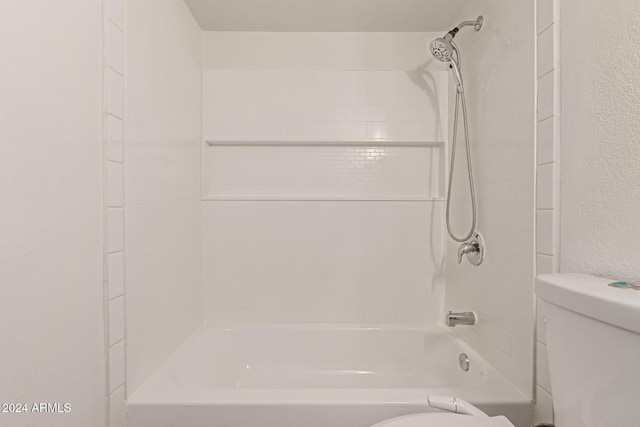 bathroom featuring tiled shower / bath combo and toilet