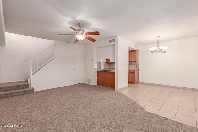 unfurnished living room featuring light tile patterned floors and ceiling fan with notable chandelier