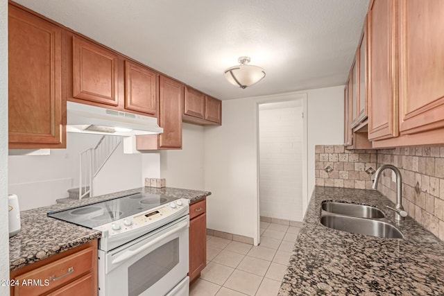 kitchen featuring backsplash, dark stone counters, sink, white electric stove, and light tile patterned flooring