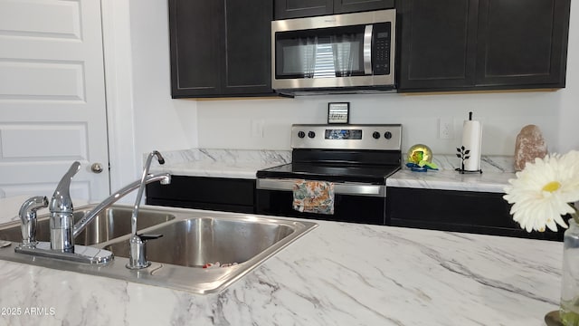 kitchen with light stone counters, sink, and stainless steel appliances