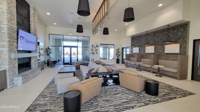 living room with french doors, a fireplace, a high ceiling, and tile patterned flooring