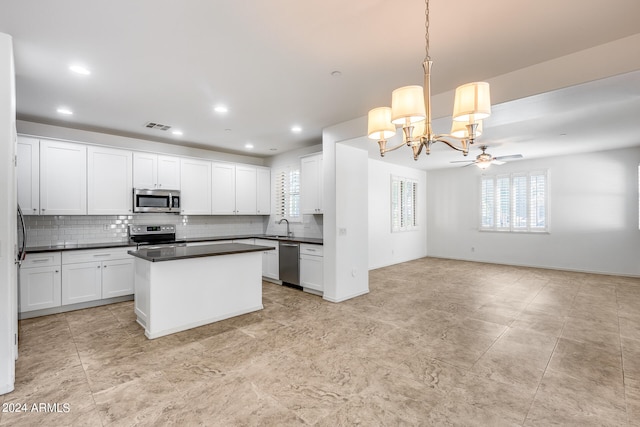 kitchen featuring white cabinetry, stainless steel appliances, sink, and pendant lighting