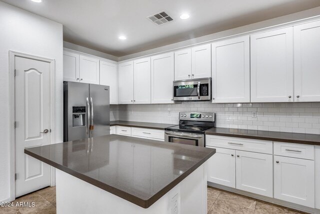 kitchen with white cabinetry, tasteful backsplash, appliances with stainless steel finishes, and a center island