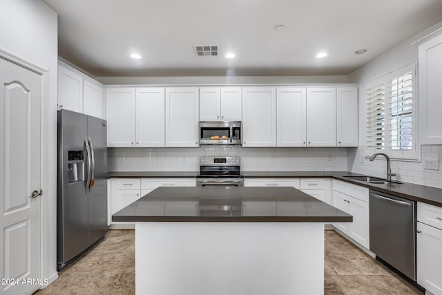 kitchen featuring sink, a kitchen island, appliances with stainless steel finishes, and white cabinetry