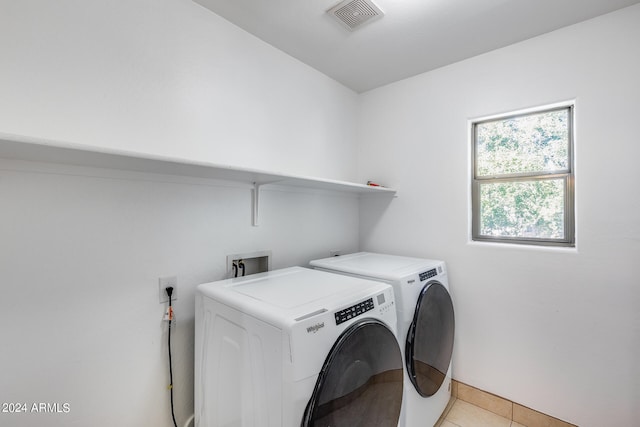 washroom with washing machine and clothes dryer and light tile patterned floors