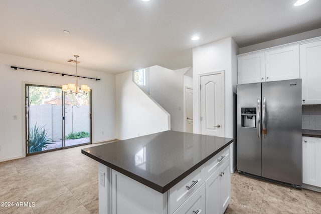 kitchen with a kitchen island, backsplash, stainless steel fridge with ice dispenser, white cabinetry, and a notable chandelier