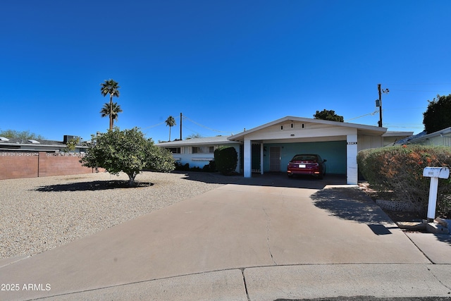 ranch-style home featuring a garage, driveway, and fence