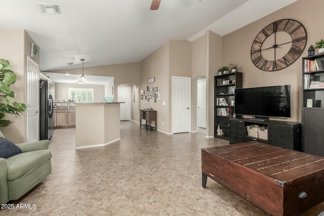 living room with ceiling fan, arched walkways, baseboards, lofted ceiling, and visible vents