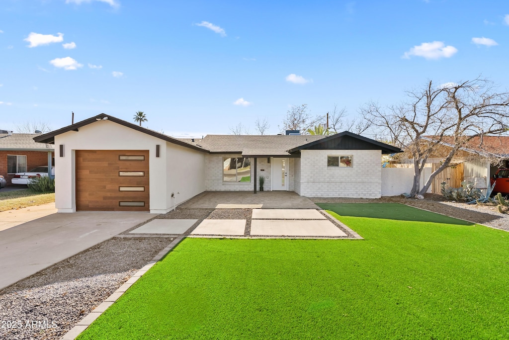 single story home featuring a garage and a front lawn