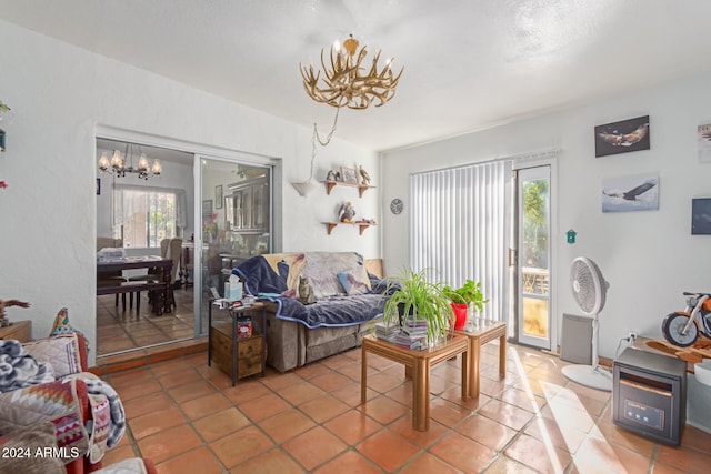 living room featuring tile patterned flooring, a notable chandelier, and a wealth of natural light