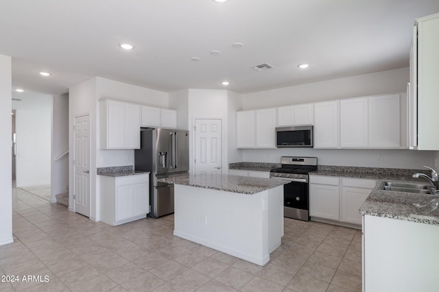 4702 S 109th Ave, Tolleson, AZ 85353 - kitchen with light stone counters, stainless steel appliances, visible vents, a sink, and a kitchen island