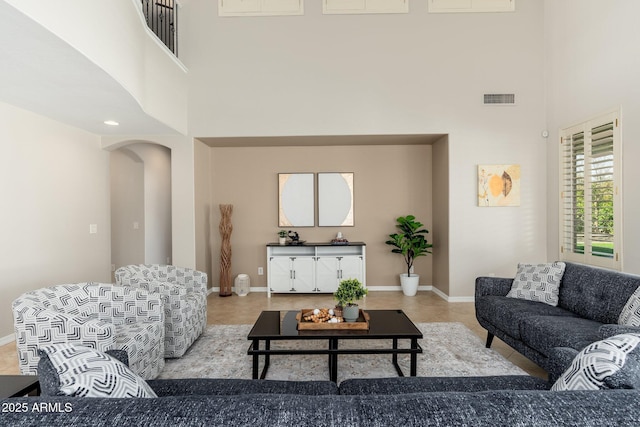 tiled living room with a towering ceiling