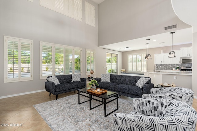 tiled living room with a high ceiling and sink