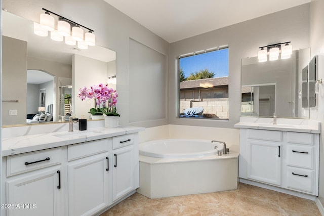 bathroom with vanity, a wealth of natural light, and a tub