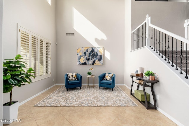 sitting room with a high ceiling and light tile patterned floors