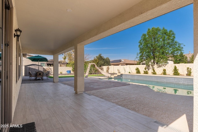 view of swimming pool featuring a water slide and a patio area