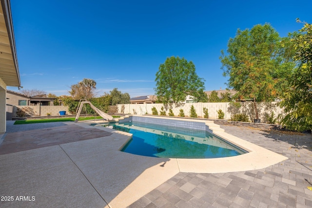 view of swimming pool with a water slide and a patio area