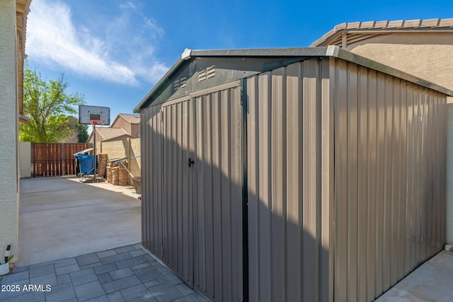 view of property exterior featuring a storage unit and a patio area