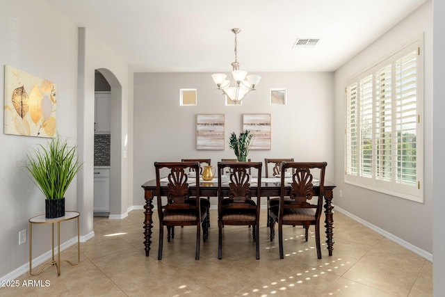 dining room with an inviting chandelier and light tile patterned floors