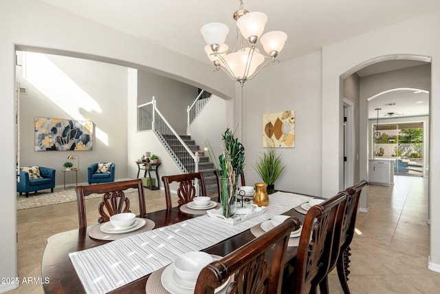 dining space featuring light tile patterned flooring and a notable chandelier