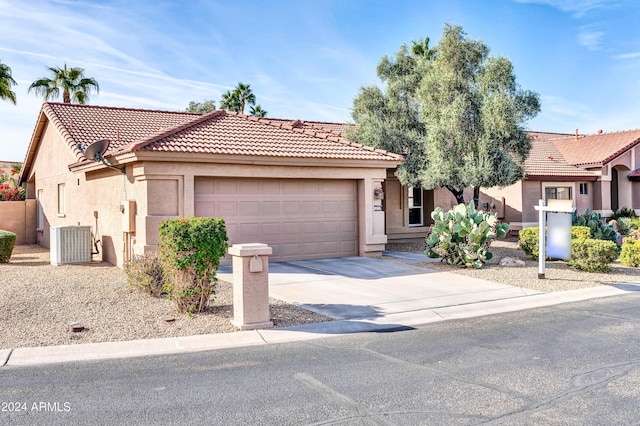 view of front of home with central AC unit and a garage