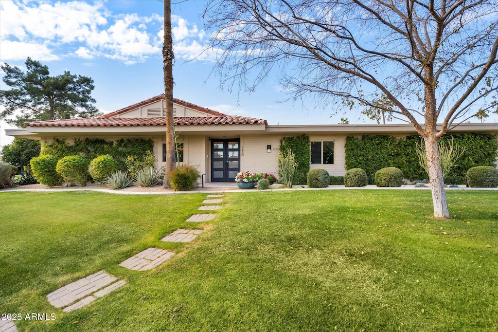 view of front facade featuring a front yard and french doors