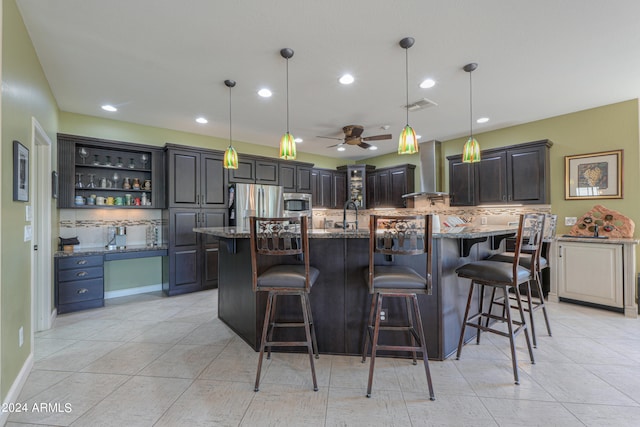 kitchen featuring a large island, tasteful backsplash, ceiling fan, a breakfast bar, and pendant lighting