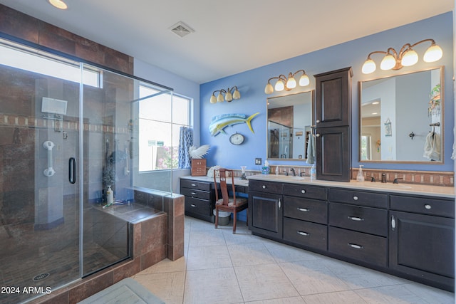 bathroom featuring vanity, a shower with shower door, and tile patterned floors