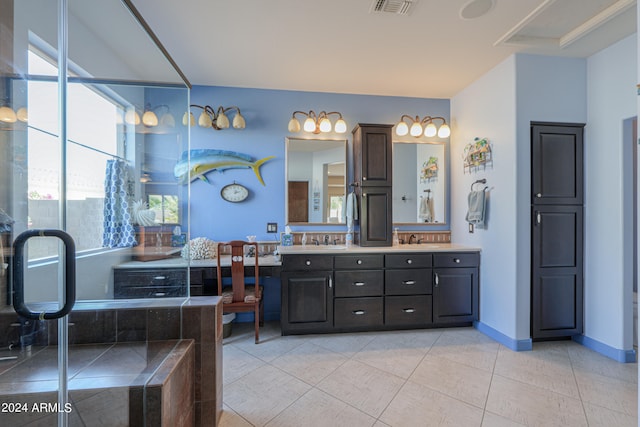 bathroom with vanity, tile patterned floors, and tiled bath