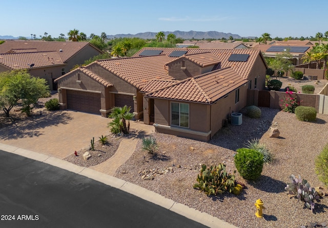 view of front of home featuring a mountain view, central AC unit, and a garage